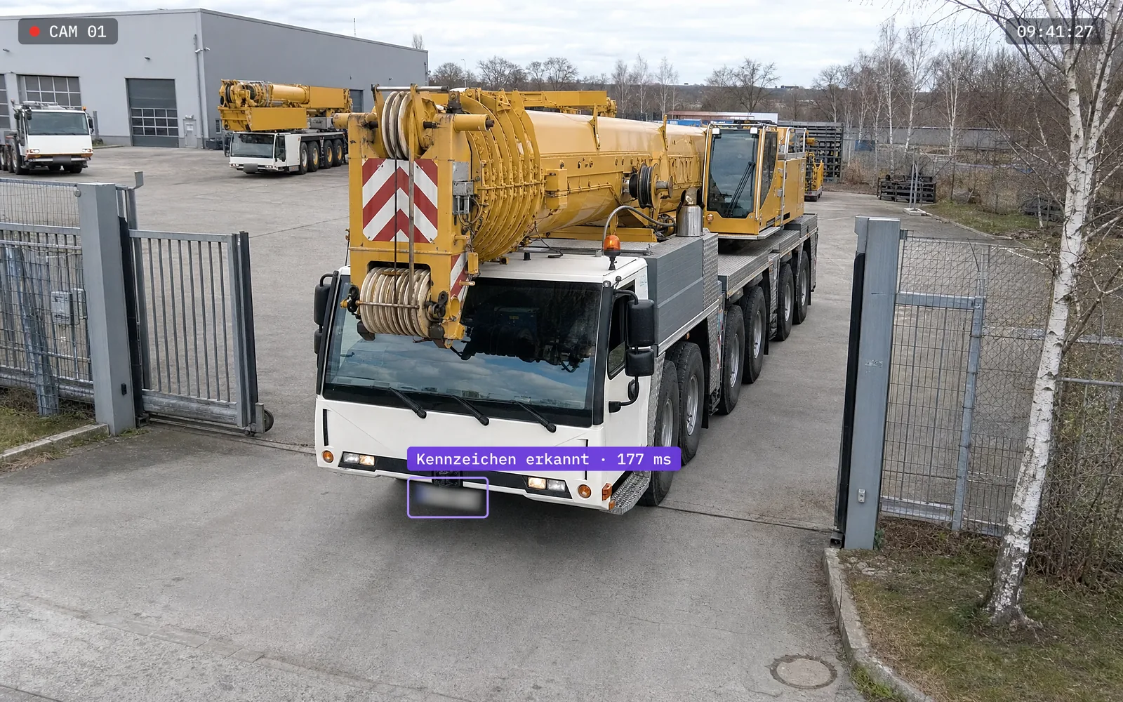 Symbolbild: Kamerabild am Werkstor eines Kranbetriebs. Ein Autokran fährt auf das Gelände, das Kennzeichen ist automatisch erkannt und unkenntlich gemacht.